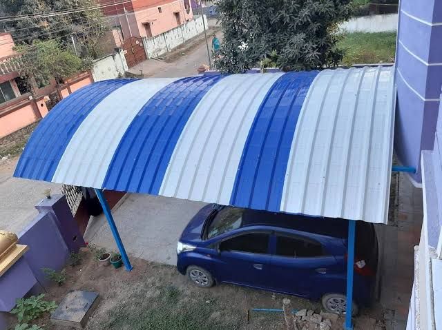 Installed curved blue and white roofing canopy over a car porch